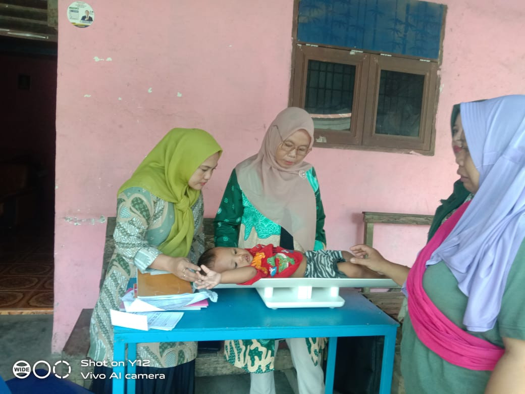 Kader Posyandu dan Perwakilan BKKBN yang diwakilkan oleh Kader PPKBD melakukan pengukuran tinggi badan terhadap peserta Posyandu Bayi