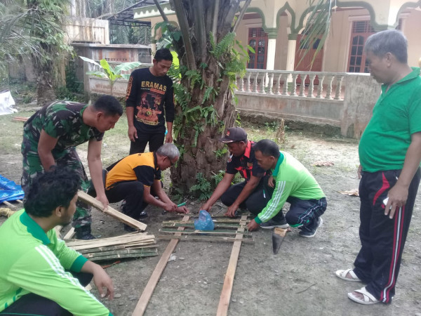 Babinsa dan Babinkamtibmas ikut serta memasang pagar