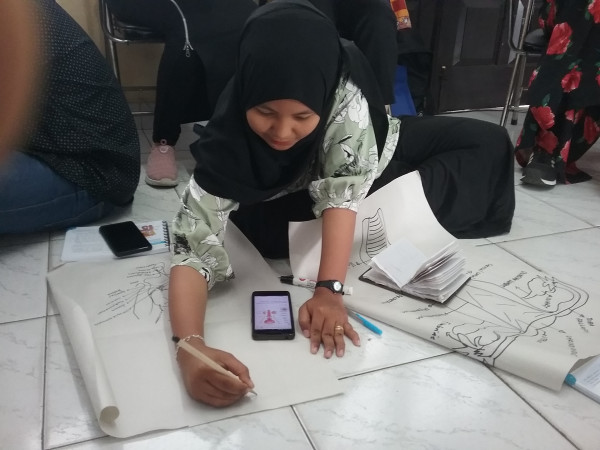 Ketua PIK R Bougenville Ceria sedang membuat gambar alat reproduksi laki-laki dan wanita