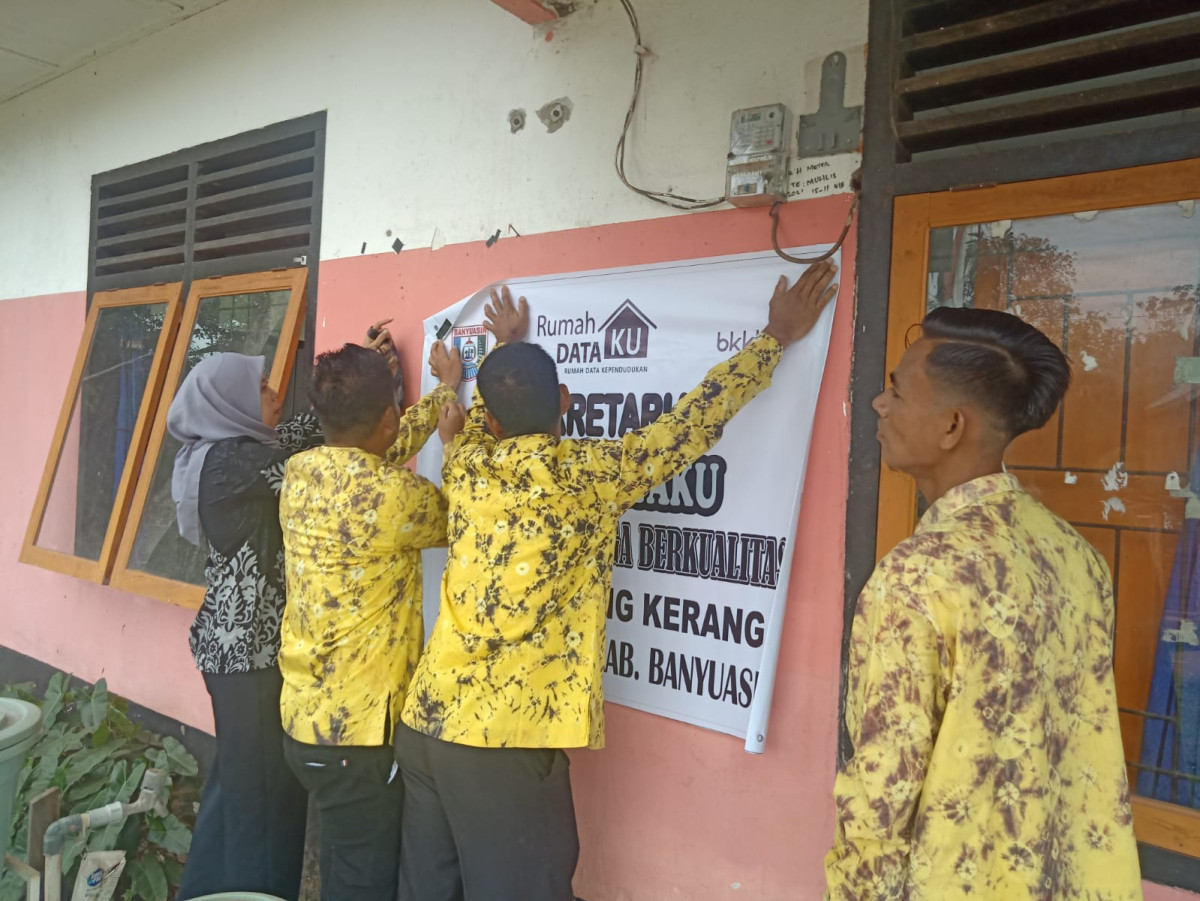 Kader Kampung KB menempelkan baner sekretariat RDK di depan kantor desa