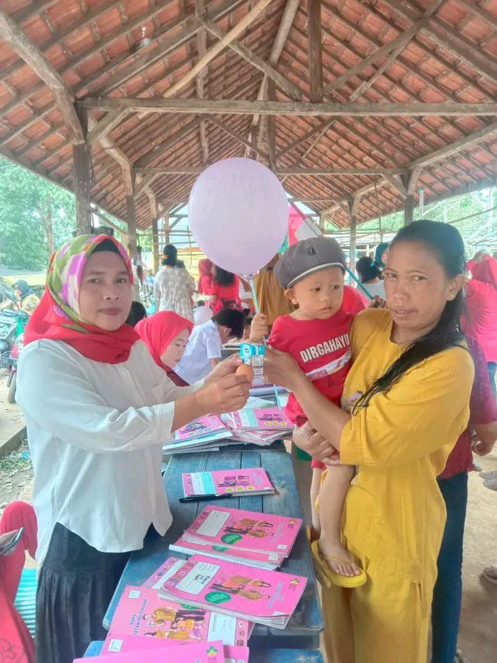 salah satu kader sedang memberi bantuan makanan berupa telur dan susu untuk balita tersebut.