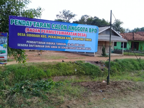 pemasangan banner pengumuman pendaftaran calon BPD Desa Sidodadi