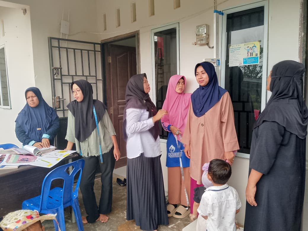 Mengukur tinggi badan orang tua yang juga membawa anaknya ke posyandu