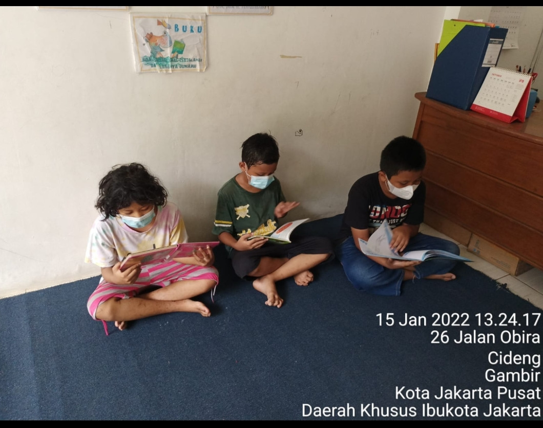 Anak anak sedang membaca buku di perpustakaan RPTRA kenanga Cideng