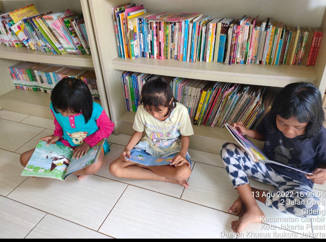 Anak-anak sedang membaca buku di perpustakaan RPTRA Kenanga