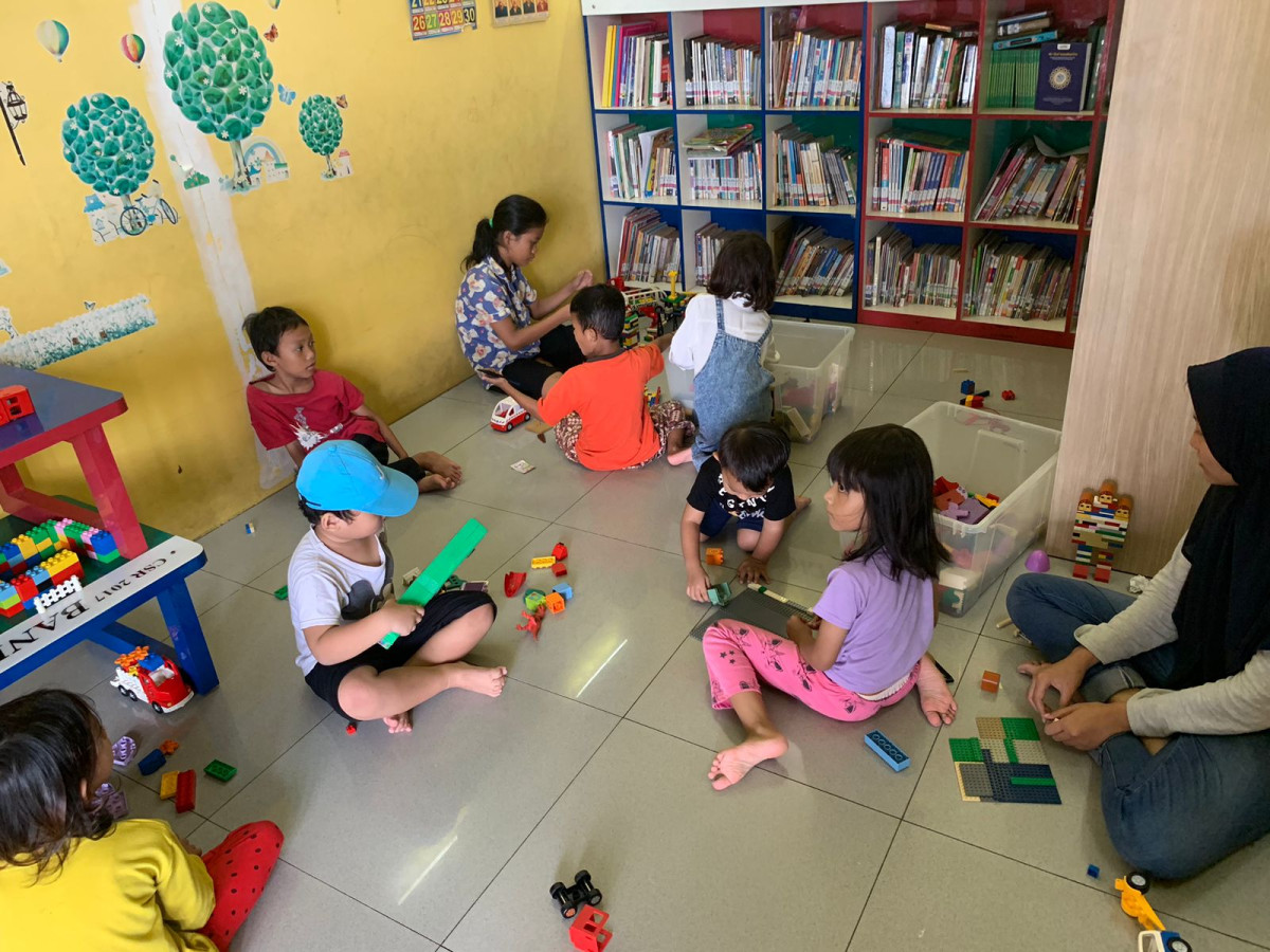 Giat Pengelola mendampingi anak-anak membaca buku dan bermain edukasi lego di Ruang Perpustakaan