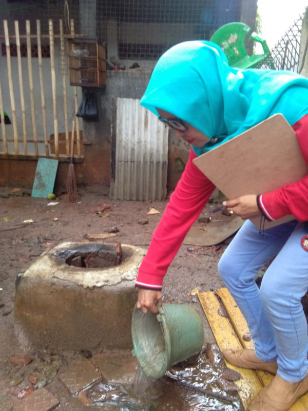 Team Jumantik melakukan pembuangan genangan air yang ada di ember bekas di pemukiman 