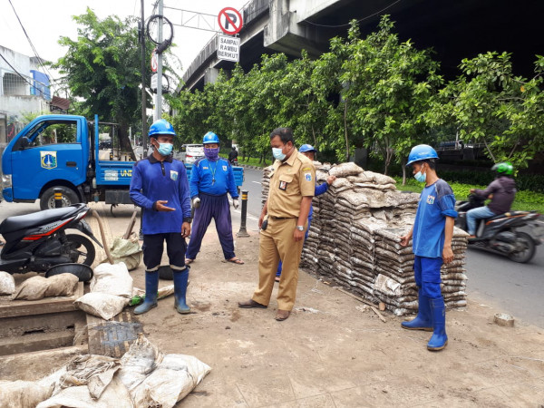 Staff Kesra Kelurahan Utan Kayu Selatan Monitor Pengurasan Saluran oleh Tim SDA di Jalan A. Yani 