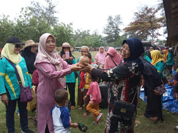 Ibu kepala desa memberikan hadiah kepada lansia yang giat mengikuti kegiatan