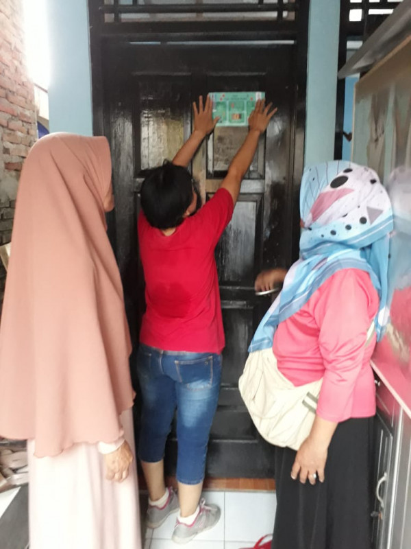 Kader IMP sedang menempel stiker di anggota BKR