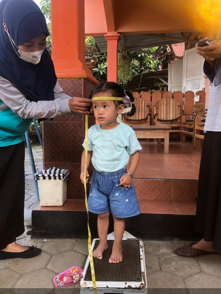 Petugas sedang mengukur tinggi badan