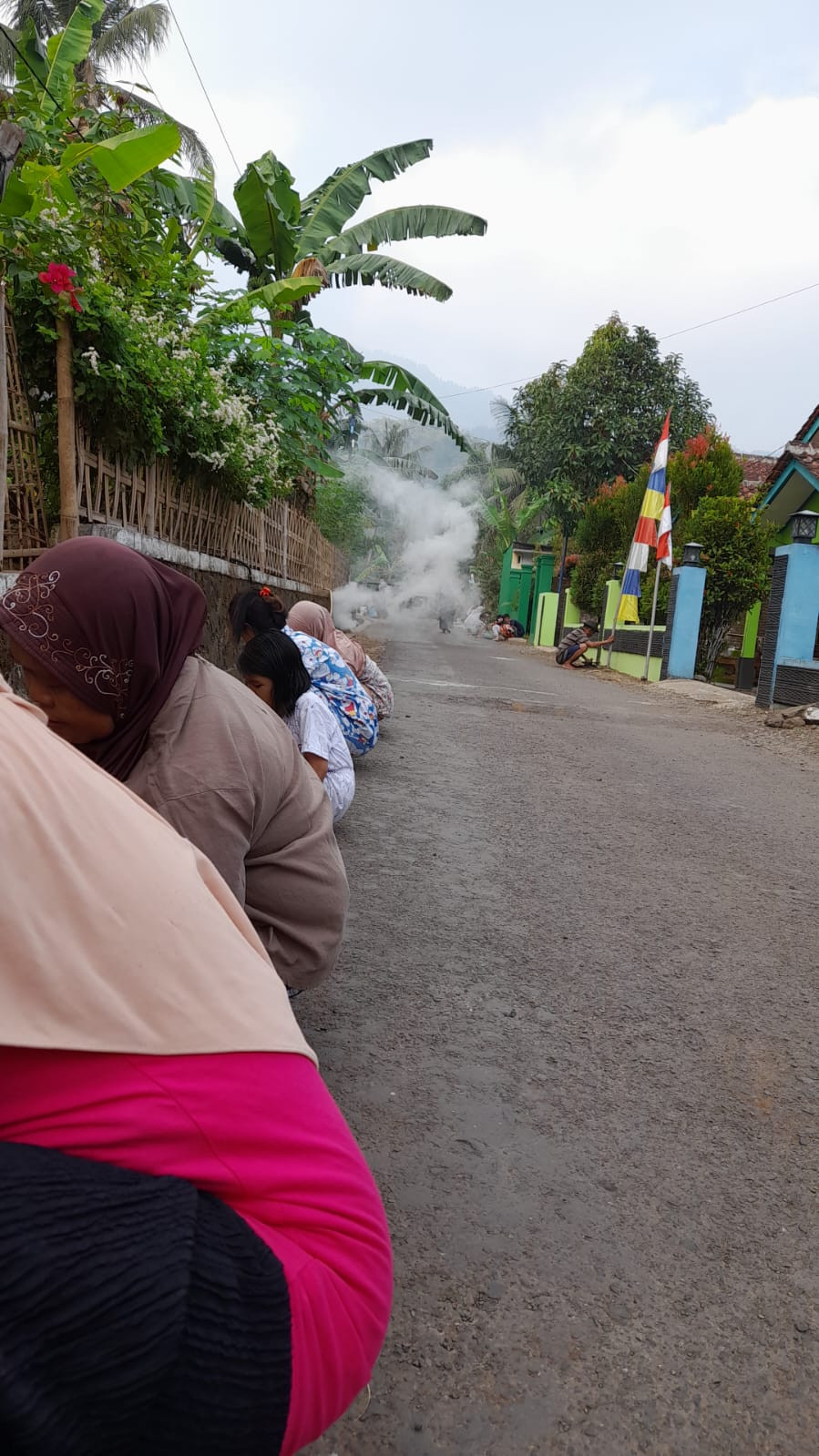 Para ibu membersihkan rumput liar disekitar jalan