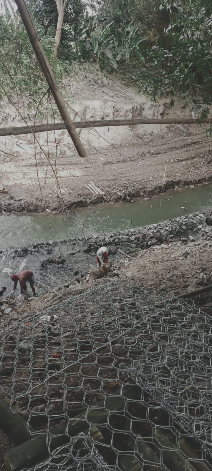 gotong royong pembangunan tanggul di tepi sungai di kawasan kampung KB