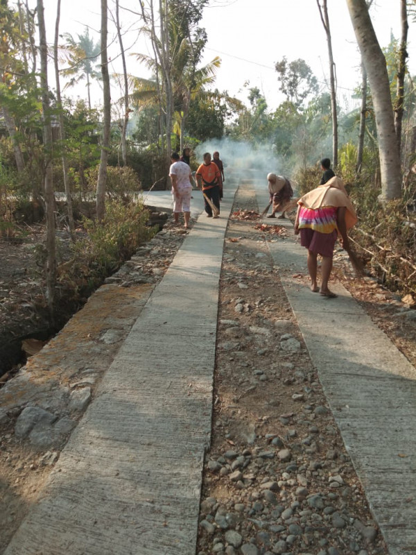 Warga menyapu halaman dan jalan dusun dari sampah dedaunan kering