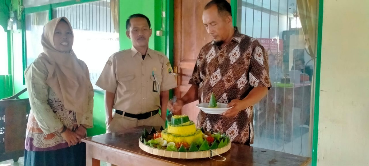 Pemotongan tumpeng oleh Ketua Kampung KB Purba Asri Krikilan Bapak Suyatno