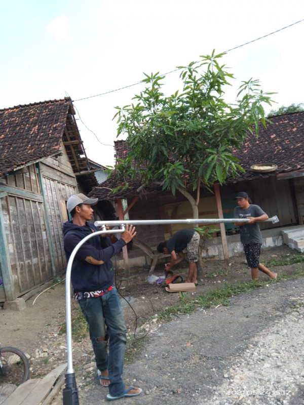 Tampak pemuda palon sedang bergotong royong mendirikan tiang lampu penerang jalan