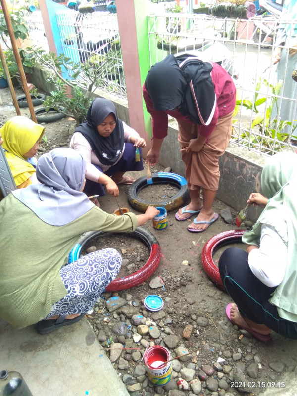 Ibu-ibu peserta BKB sedang mengecat ban bekas untuk membuat pot tanaman