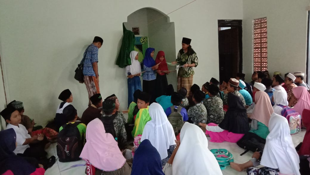 pemberian kitab oleh Ustadz kepada murid madrasah