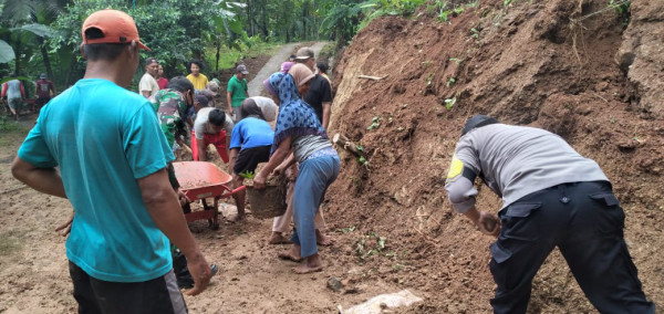 Warga masyarakat Girinyono melaksanakan kerja bakti membersihkan longsoran yang menimpa jalan 