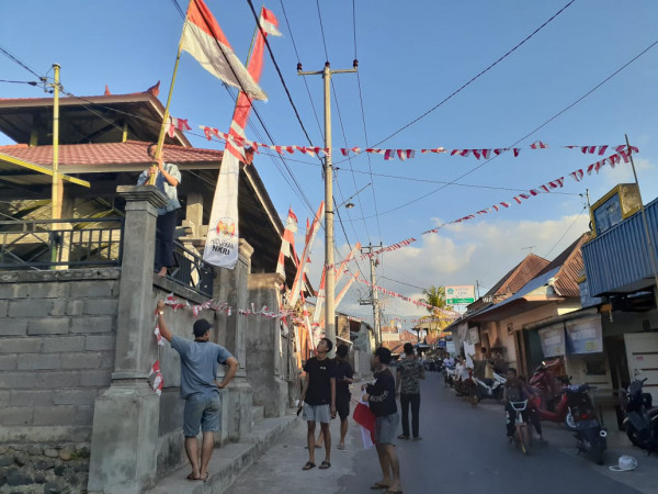 Proses Pemasangan Bendera dan Umbul-umbul di Balai Banjar Desa Poh Bergong