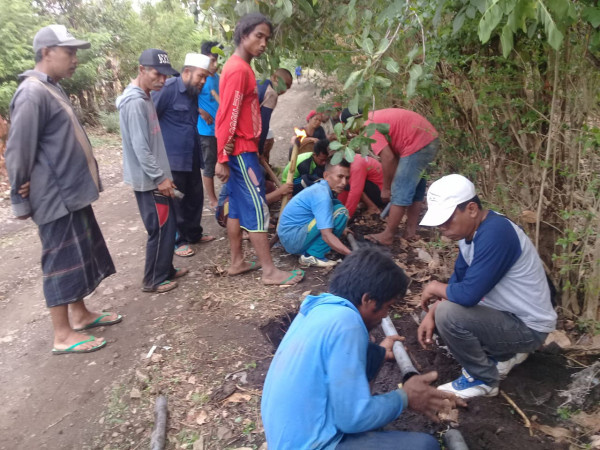 Pemasangan pipa air dikerjakan secara gotong royong oleh warga desa