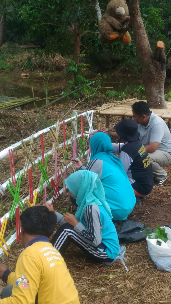 Lurah dan Tim Satgas melakukan pengecatan hiasan bambu paring di Sungai Biuku