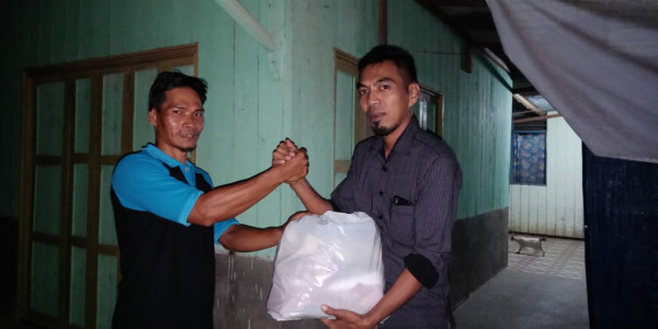 serah terima dari ketua Kampung KB kepada salah satu relawan Yayasan Paser Peduli