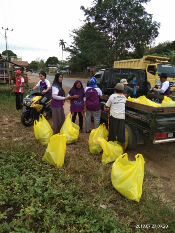 Ibu-ibu pokja kampung KB bersama warga memungut sampah plastik