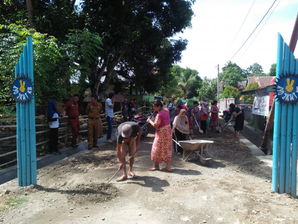 masyarakat tengah kerja bakti membersihkan jalan pasca pembuatan saluran air