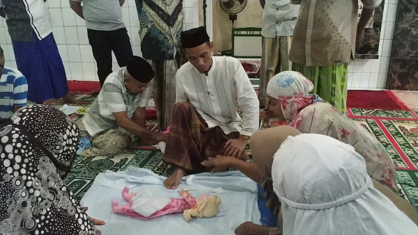 pelatih memperlihatkan cara mengkafani jenazah