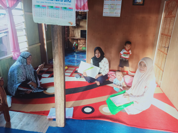 Salah satu Ibu menerima Buku Kartu Kembang Anak