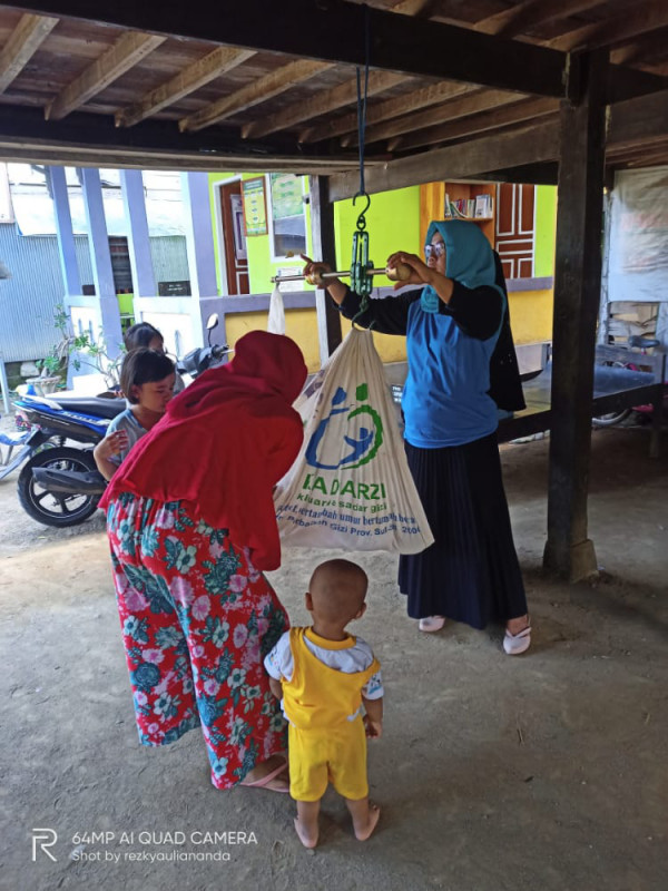 penimbangan oleh kader posyandu