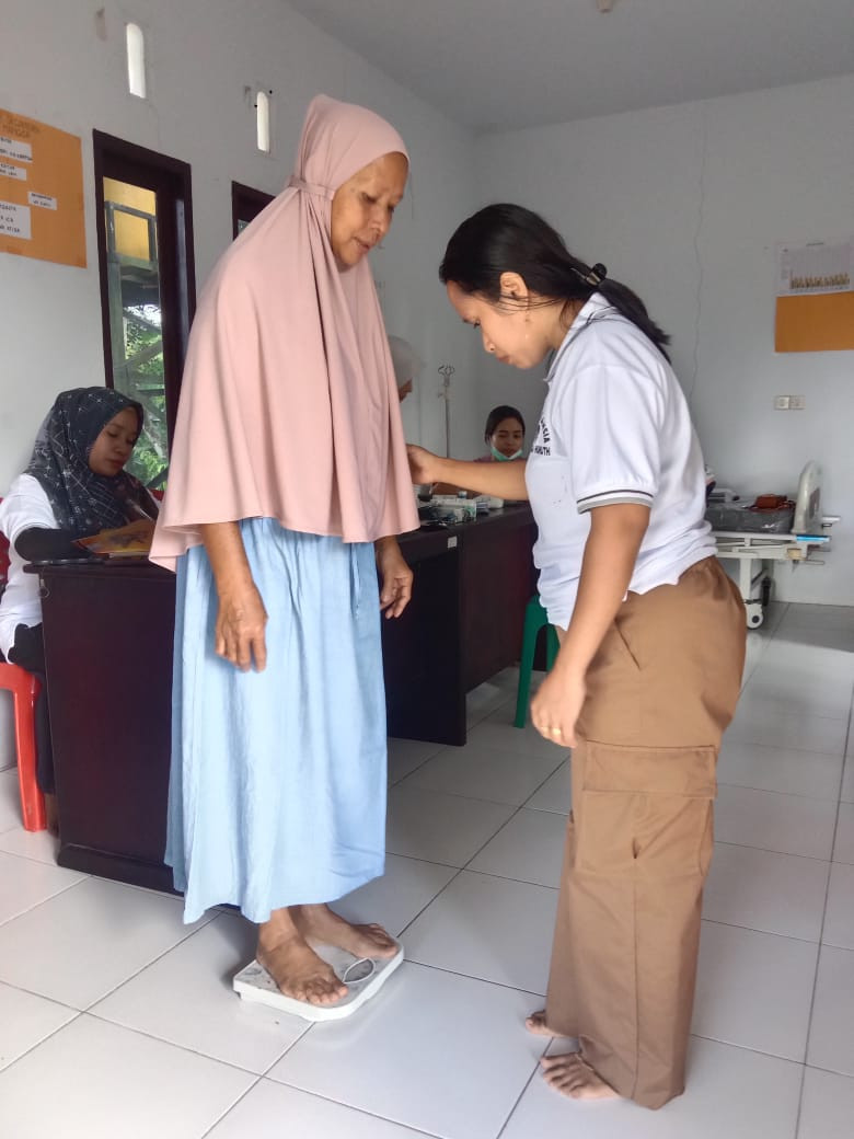 Penimbangan berat badan lansia oleh kader BKL