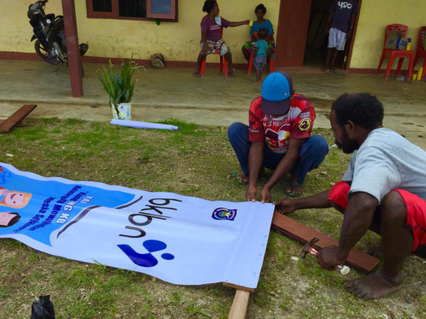 Proses pemasangan banner di Kampung KB Fafi